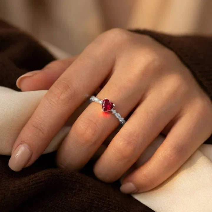 Anel de ouro com coração de rubi da Rose & Oliver, destaque para o design delicado com pedra vermelha central.
