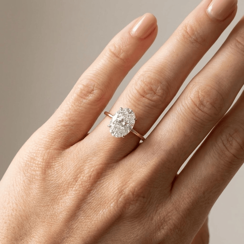 Anel de diamante oval solitário Rose & Oliver com banda de ouro, destaque para o diamante central brilhante e elegante.