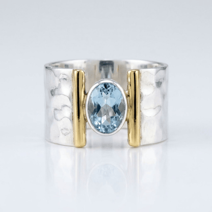 Anel moderno de prata, ouro e topázio com design elegante, da marca Rose & Oliver, mostrando detalhes da joia.