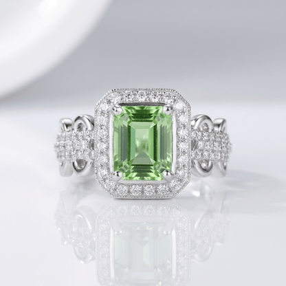 Anel de halo com esmeralda da Rose & Oliver, joia elegante com pedra central verde e acabamento brilhante.