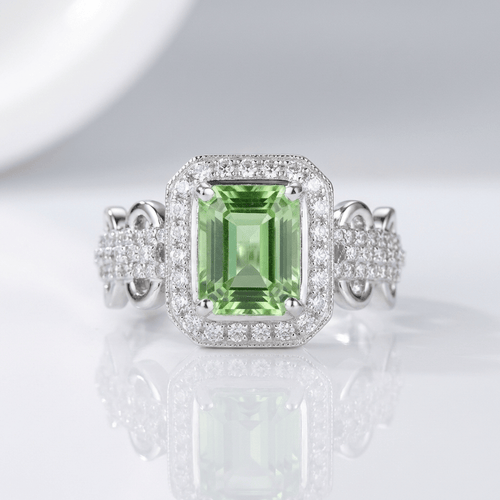 Anel de halo com esmeralda da Rose & Oliver, joia elegante com pedra central verde e acabamento brilhante.