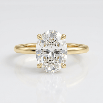 Anel de ouro oval com diamante solitário da Rose & Oliver, exibindo um design elegante com diamante central brilhante.
