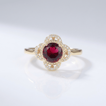 Anel de ouro com rubi, diamantes e halo, da marca Rose & Oliver, exibindo detalhes refinados e brilho elegante.