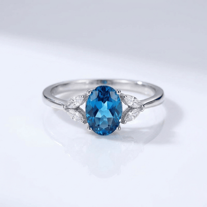 Anel ajustável com topázio oval azul prateado da Rose & Oliver, destaque para a pedra brilhante e a moldura elegante.