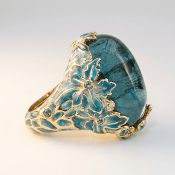 Anel de ouro com flor de apatita azul, joia elegante da marca Rose & Oliver, com detalhes delicados e pedras brilhantes.