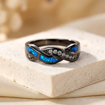 Anel de prata com entalhes torcidos e detalhes em inlay, da marca Rose & Oliver, exibido em close em fundo neutro.
