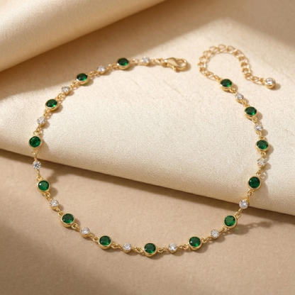 Colar de gargantilha com esmeraldas verdes e detalhes em ouro, da marca Rose & Oliver, exibido em fundo neutro.