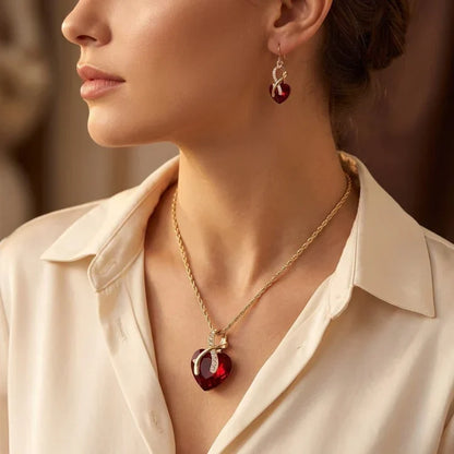 Conjunto de Jóias Rose & Oliver com coração torcido em ouro e rubis, incluindo brincos e colar delicado com pedras vermelhas.