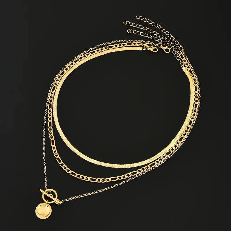 Collar dorado Rose & Oliver Savira con capas texturizadas y detalles de monedas destacados.