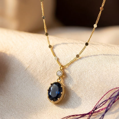 Colar de ouro com gota oval de safira, joia elegante da marca Rose & Oliver, destaque em peça de expressão sofisticada.