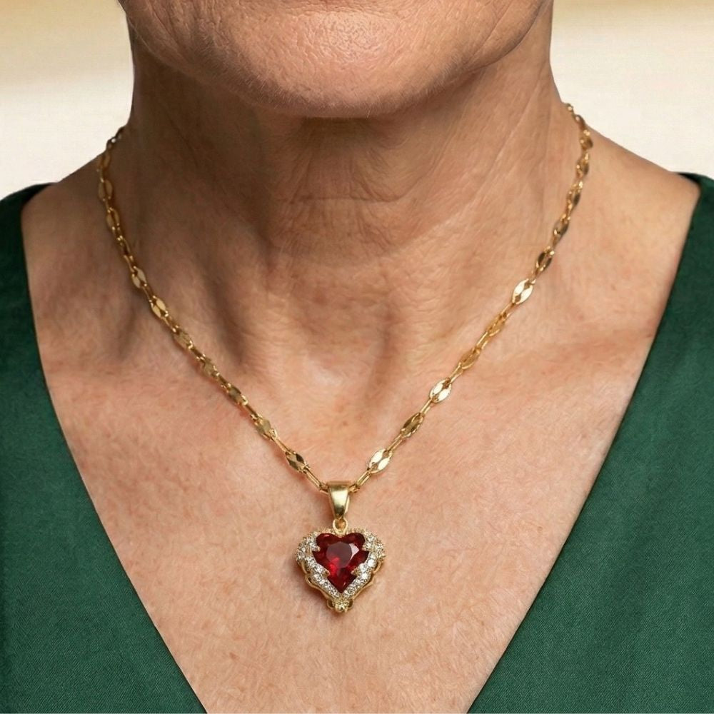 Colar Angel Embrace com coração de rubi da Rose & Oliver, peça delicada com pingente de anjo e gema vermelha brilhante.