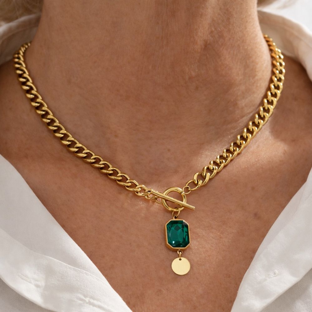 Colar com pingente de esmeralda da Rose & Oliver, destaque na imagem, com corrente de prata e pedra verde brilhante.