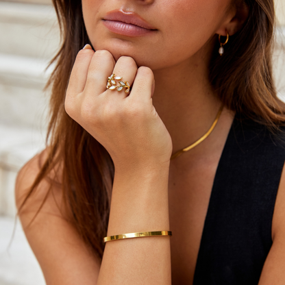 Anel com motivo de folha de ouro da Rose & Oliver, acabamento dourado, detalhes delicados e design elegante, em destaque na imagem.