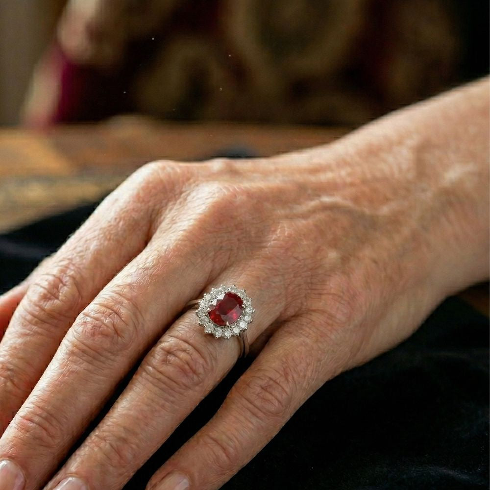 Anel Rose & Oliver com coroa escarlate e rubi central, detalhe de joia elegante em prata ou ouro.