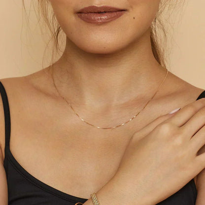 Colar Bodega™ Gold Box da Rose & Oliver com pingente retangular em acabamento dourado, sobre fundo neutro.