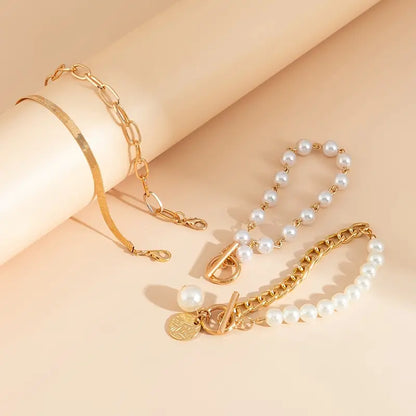 Set aus 4 goldenen Armbändern mit Schlangen-, Perlen- und Gliederdetails, von Rose & Oliver, im eleganten und raffinierten Stil.