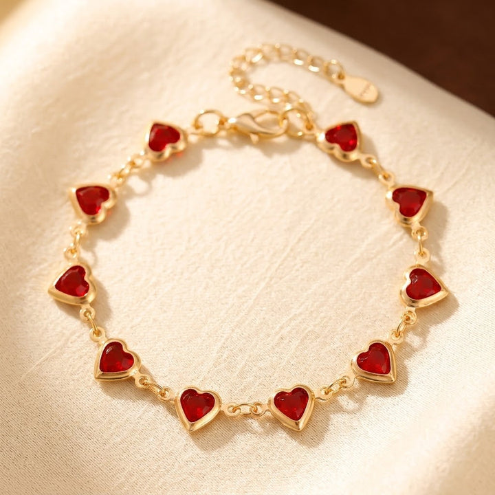 Pulseira de ouro com coração e rubi, da marca Rose & Oliver, mostrando detalhes delicados e acabamento brilhante.
