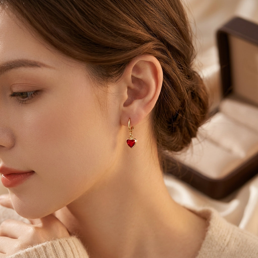 Brincos de ouro com gotas de rubi em formato de coração, da marca Rose & Oliver, com detalhes elegantes e acabamento refinado