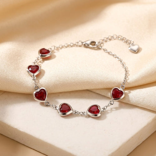 Pulseira de corrente com coração de rubi e detalhes em prata, da marca Rose & Oliver, exibida na imagem.