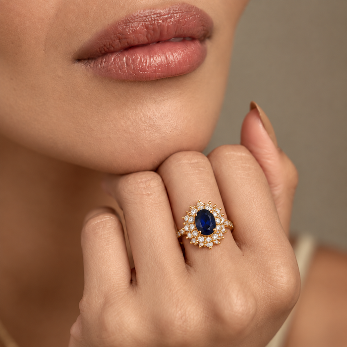 Anel de ouro com halo de safira azul, da marca Rose & Oliver, exibindo detalhes elegantes e acabamento brilhante.