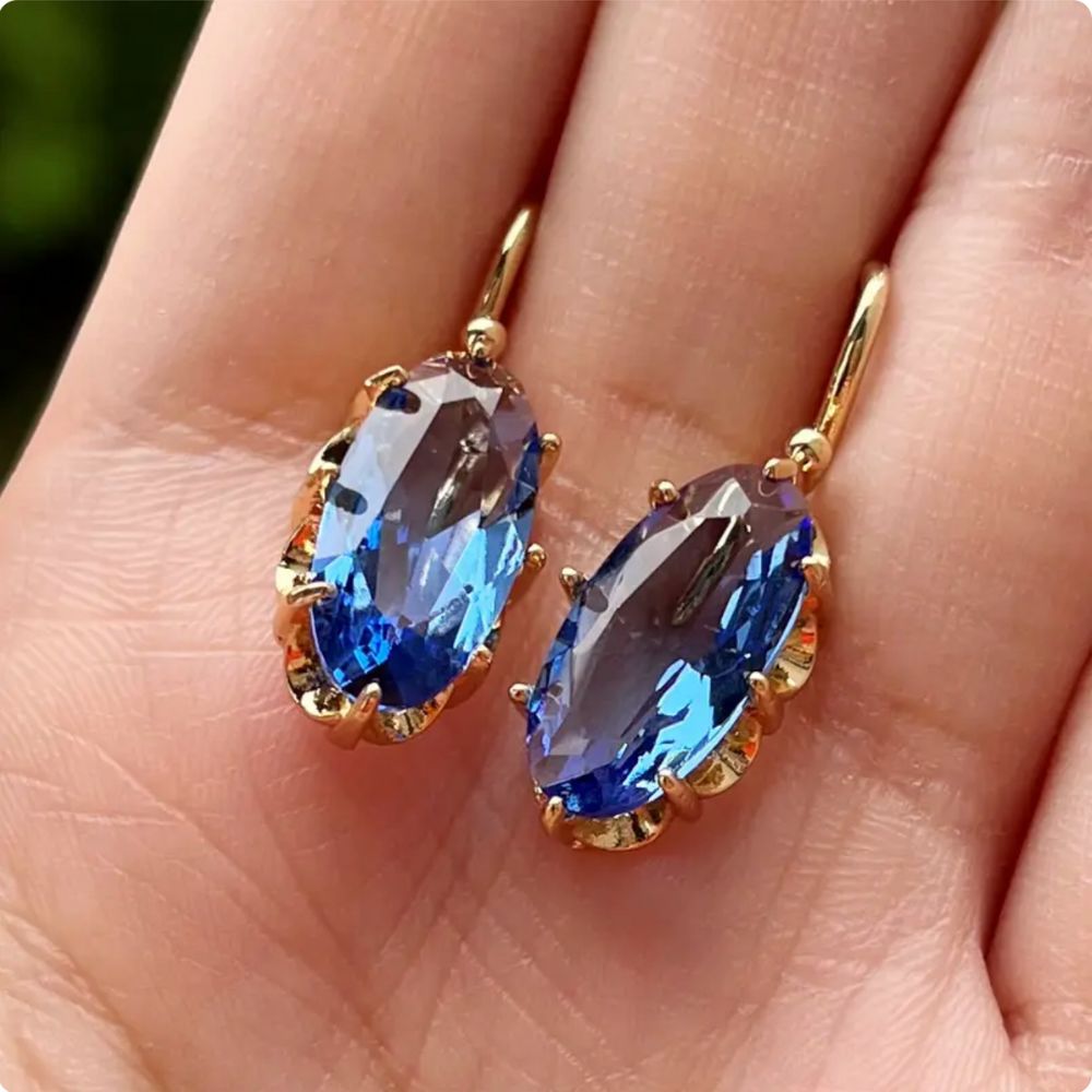 Pendientes dorados y azules con diseño floral de la marca Rose & Oliver, detalles delicados y acabado elegante.